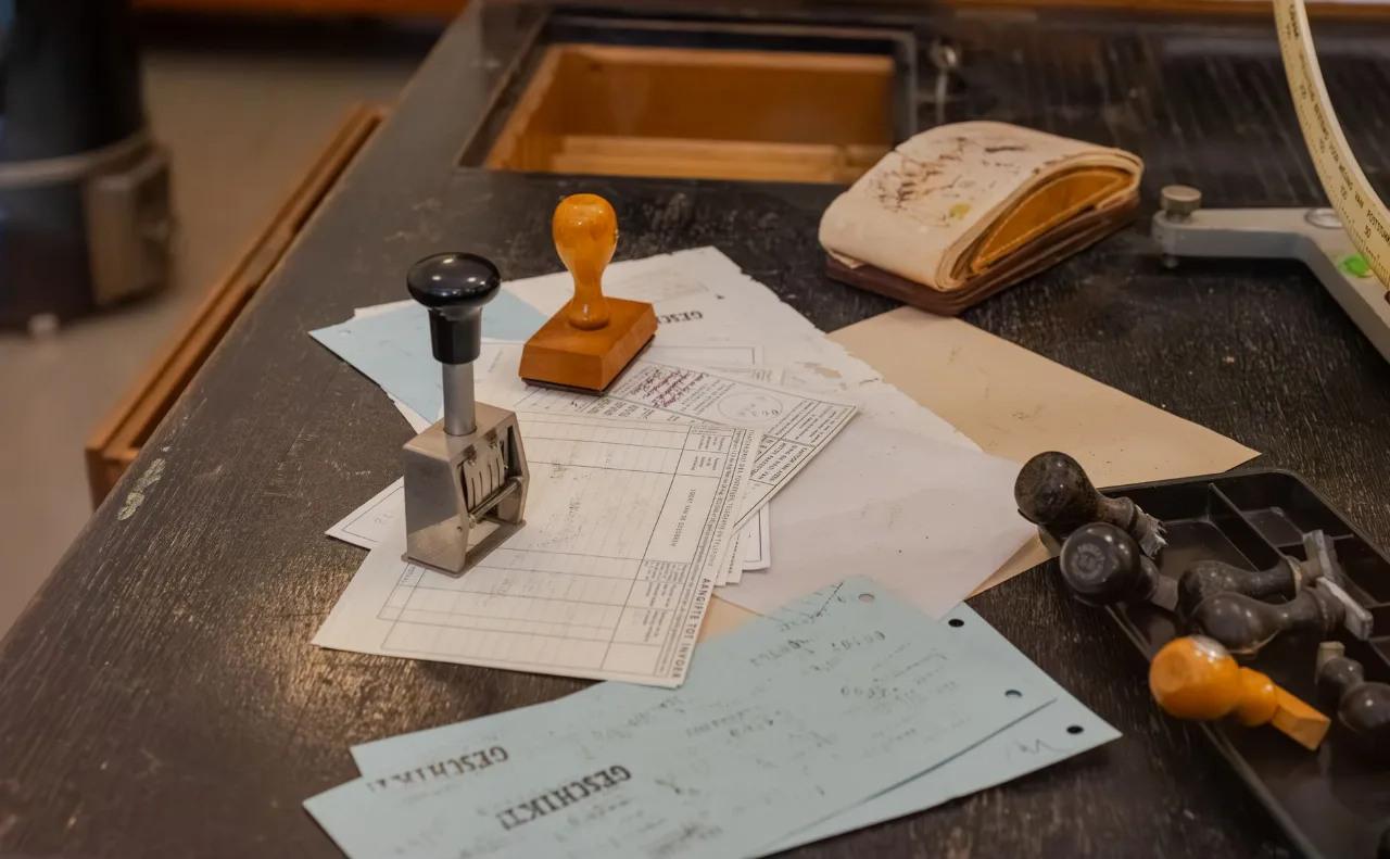 Mesa de escritório com carimbos de madeira apoiados sobre vários documentos fiscais